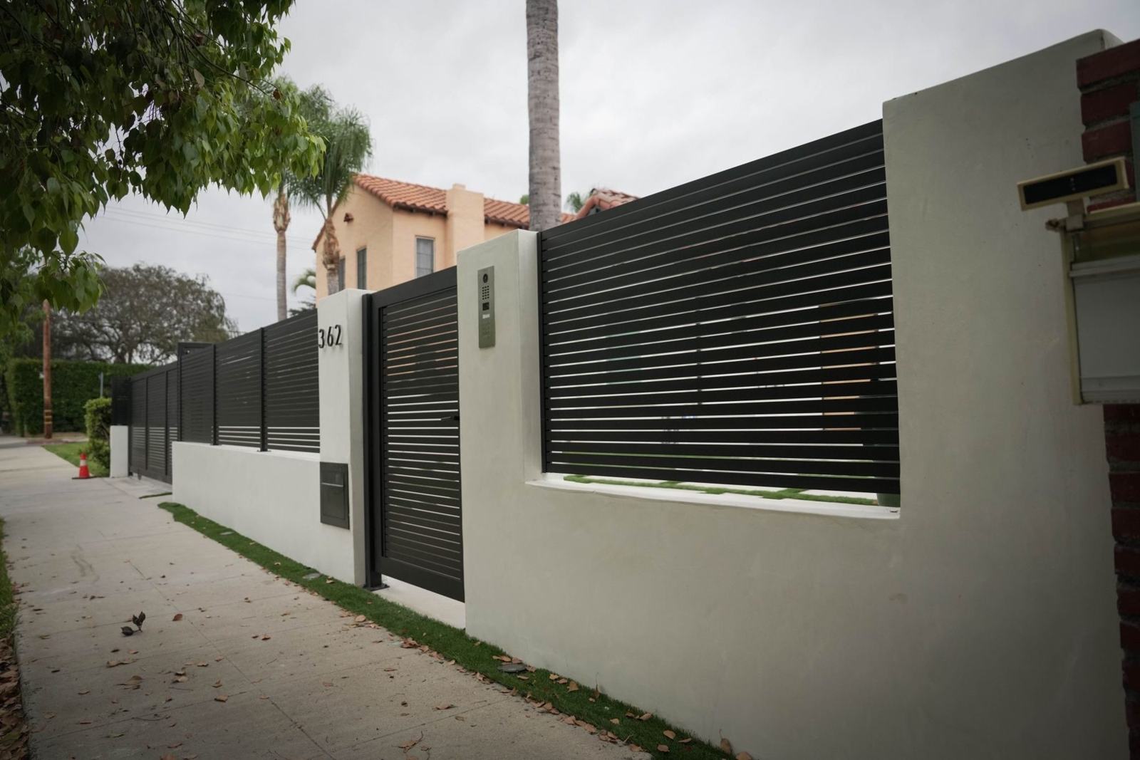 Stucco wall with slat fence and gate