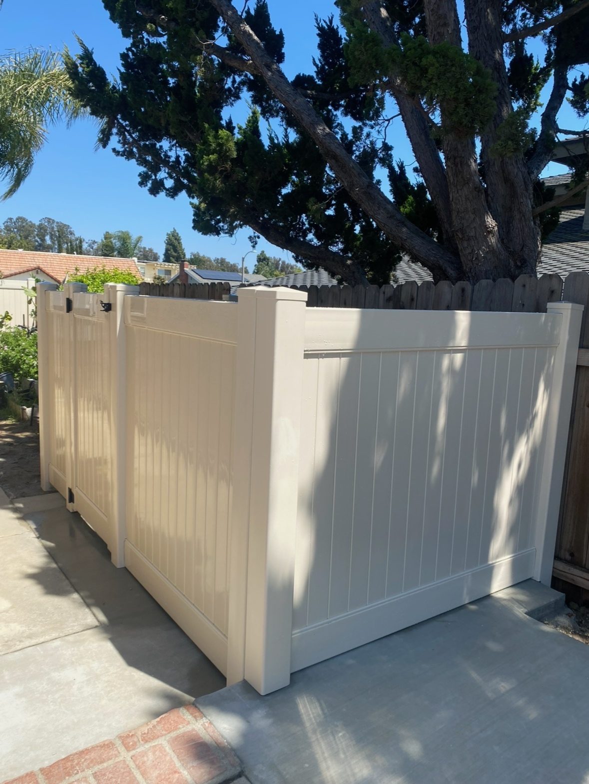 Tan vinyl privacy fence with a walk gate