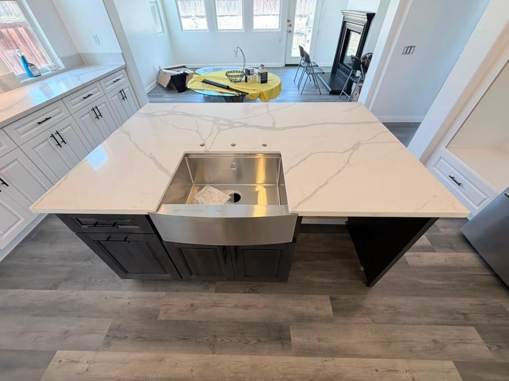 Kitchen island with farmhouse sink and marble-look quartz