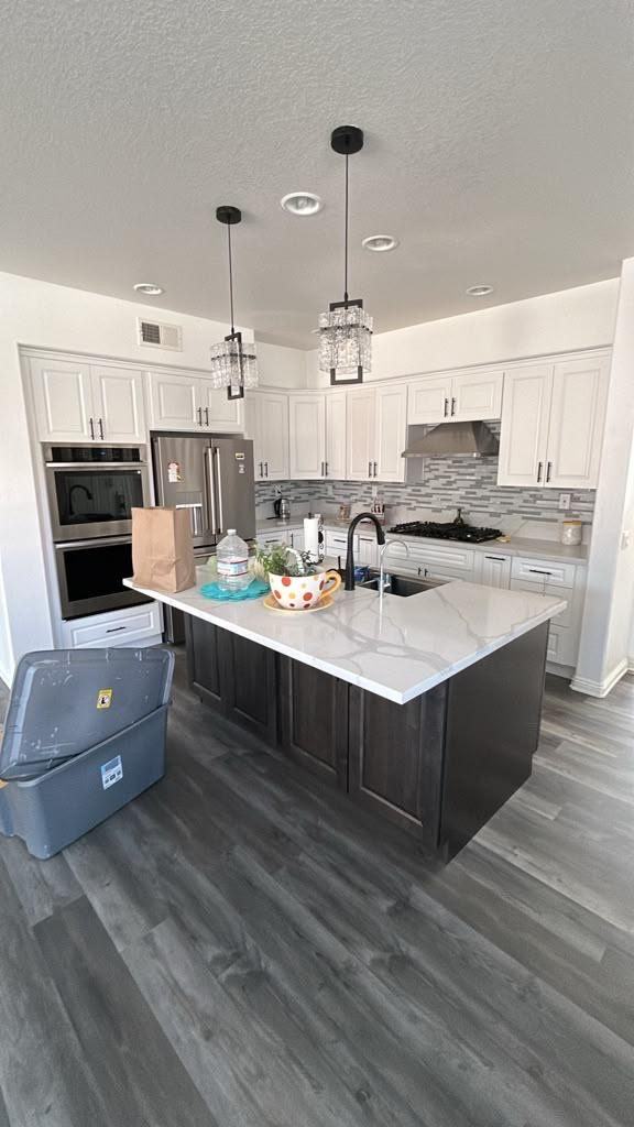 White kitchen with dark island and pendant lights
