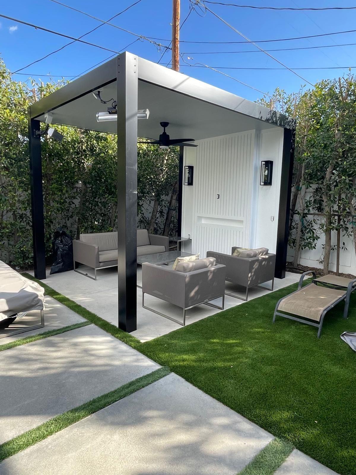 Modern patio cover over turf and lounge seating
