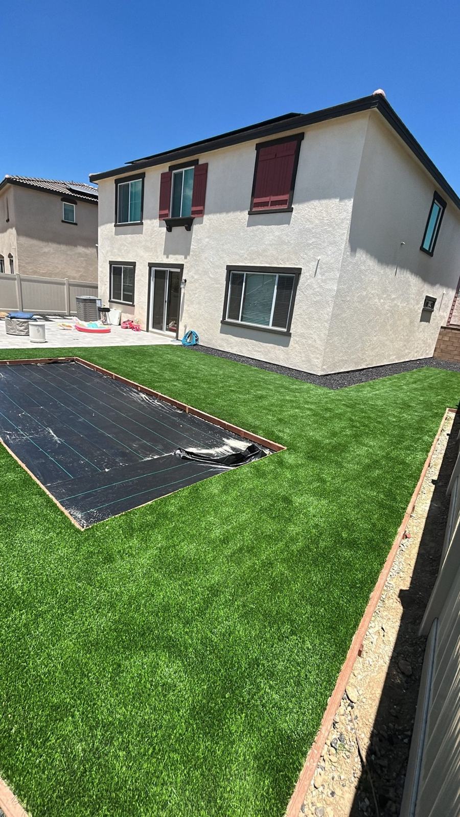 Turf backyard behind a two-story home