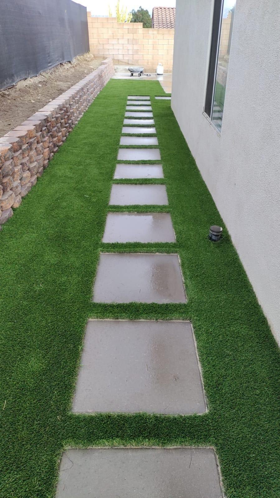 Concrete steppers through side yard turf next to a block wall